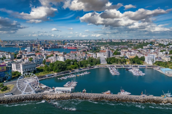 skyline of buildings along bodies of water and a ferris wheel